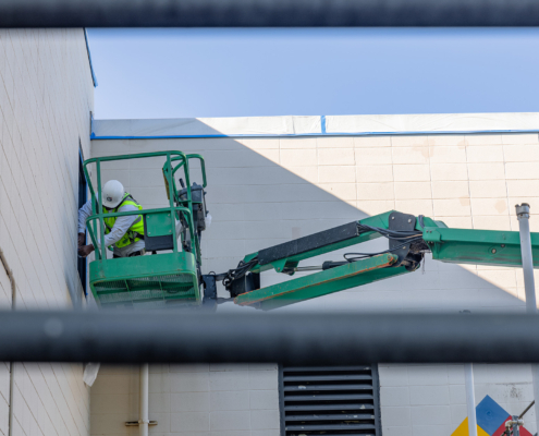 Side view of man painting exterior of building